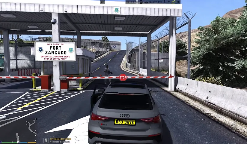 Kasi Vibes 17 A scene from the GTA Mzansi files, Kasi Vibes, in which a car approaches a security checkpoint with a sign that reads "Welcome to Fort Zancudo" and a stop signal.
