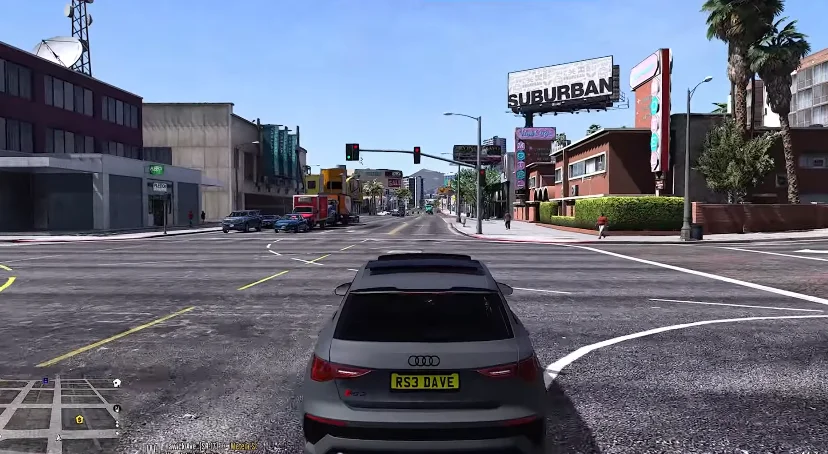 A screenshot from GTA Mzansi Kasi Vibes APK presenting a street view with a grey Audi parked in the foreground, traffic lights, and various buildings and signs, including one that says "SUBURBAN".