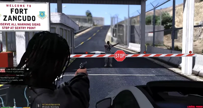 A scene from a video game, gta mzansi online kasi vibes, showing a character pointing a weapon at a security checkpoint with a stop sign, labeled "Fort Zancudo."