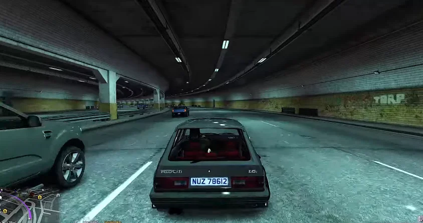 Kasi Vibes 15 Kasi Vibes stereo hearts: a grey hatchback with a red interior drives through a dimly lit concrete tunnel with graffiti on the walls, seen from a third-person perspective view.